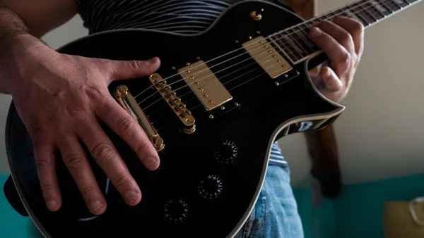 Close Uma Pessoa Tocando Uma Guitarra Elétrica Preta Sob Luzes — Fotografia de Stock