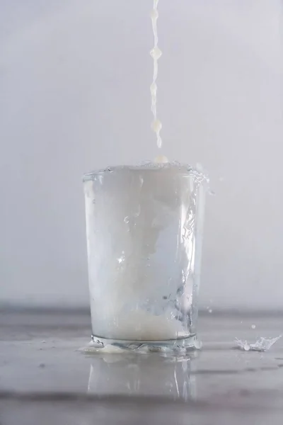 Colpo Verticale Latte Cadere Una Tazza Vetro Riempito Con Acqua — Foto Stock