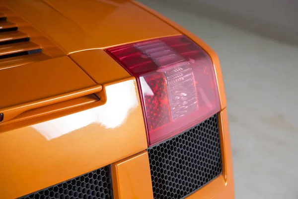 Zbliżenie Ujęcie Podświetlenia Nowoczesnego Pomarańczowego Samochodu — Zdjęcie stockowe