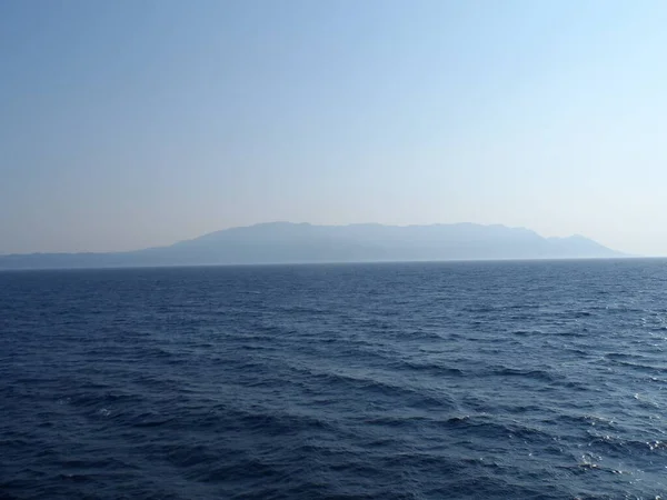 Красивый Снимок Спокойного Моря Размытой Землей Заднем Плане — стоковое фото