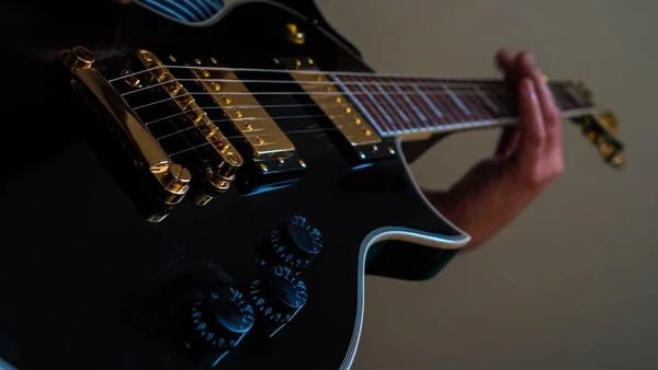 Baixo Ângulo Fechamento Uma Pessoa Tocando Uma Guitarra Elétrica Preta — Fotografia de Stock