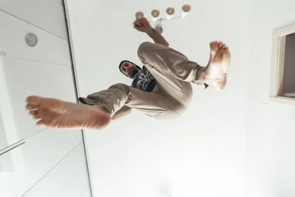Low Angle Shot Male Jumping His House White Ceiling — Stockfoto