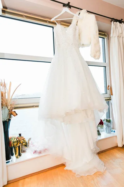 背景に窓のある壁から垂直な白いウェディングドレスのショット — ストック写真