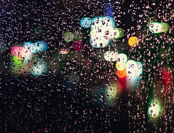 Ένα Παράθυρο Καλυμμένο Σταγόνες Βροχής Κάτω Από Φώτα Θολή Φόντο — Φωτογραφία Αρχείου