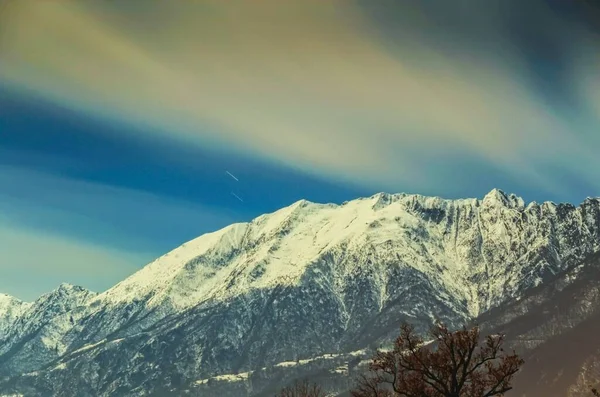 昼間の美しい空の下で雪の山の魅惑的な写真 — ストック写真