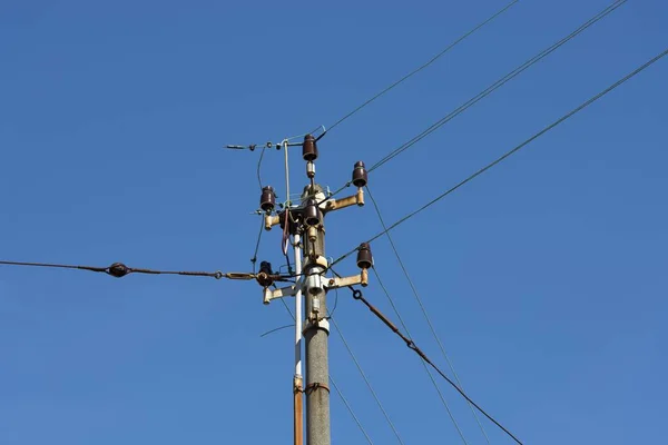 澄んだ青い空に対するワイヤを持つ電気ポストの閉鎖 — ストック写真