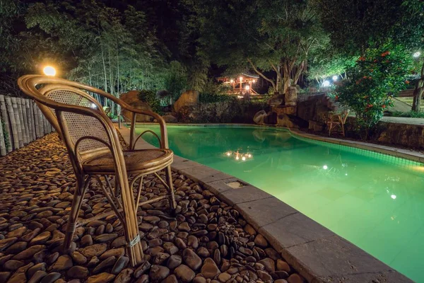 Geceleri Yapraklarla Çevrili Bir Havuzun Yanındaki Tahta Sandalyenin Güzel Bir — Stok fotoğraf