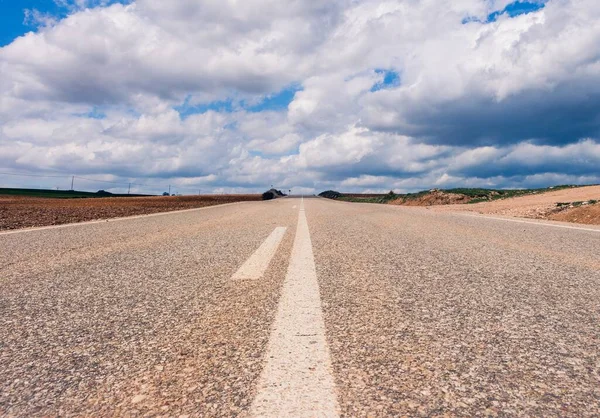 Een Lege Weg Omringd Door Heuvels Onder Een Prachtige Bewolkte — Stockfoto