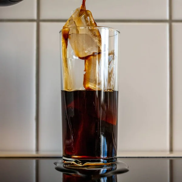 Красивый Вертикальный Снимок Кофе Льющегося Стакан Полный Льда — стоковое фото