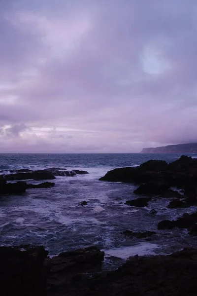 Una Vista Fascinante Las Rocas Océano Bajo Cielo Púrpura Ubicado — Foto de Stock