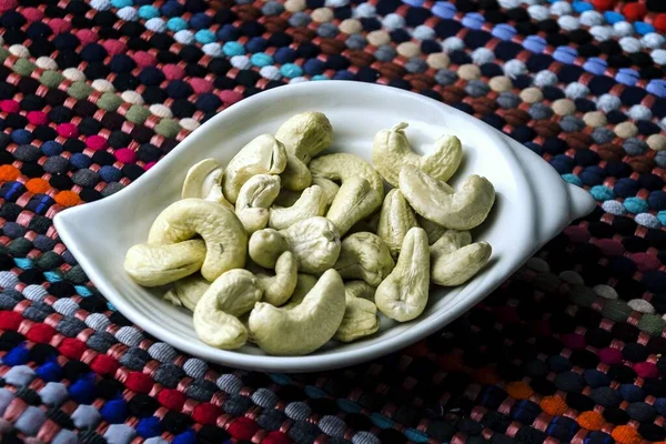 Een Close Shot Van Cashewnoten Een Witte Plaat Een Kleurrijk — Stockfoto