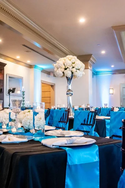 一个有蓝色椅子和白花的婚礼大厅的垂直照片 — 图库照片