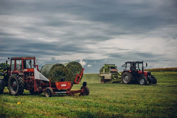 Una Vista Horizontal Tractores Cosechando Hierba Bajo Cielo Nublado — Foto de Stock