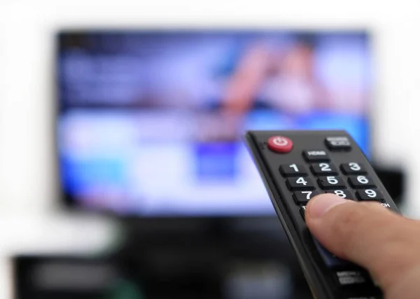 Mão Segurando Controle Remoto Uma Tela Fundo Dobradiça Assistindo Programa — Fotografia de Stock