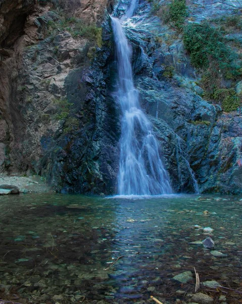Eine Vertikale Aufnahme Eines Wasserfalls Der Die Felsen Hinunterfällt — Stockfoto