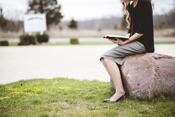 Een Vrouw Die Een Rots Zit Terwijl Een Boek Leest — Stockfoto