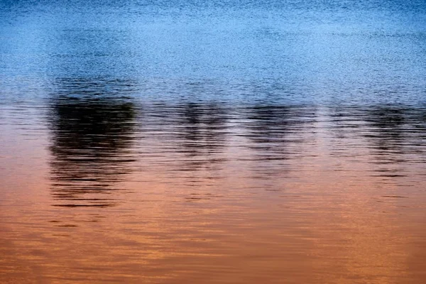 Belo Tiro Pôr Sol Refletido Água Com Cores Laranja Azul — Fotografia de Stock