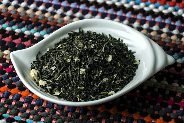 Zbliżenie Zieloną Herbatę Jasmin Białym Talerzu Kolorowym Obrusie — Zdjęcie stockowe