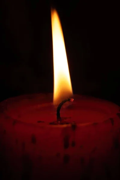 Вертикальный Снимок Маленького Пламени Горящего Красной Свече Черном Фоне — стоковое фото