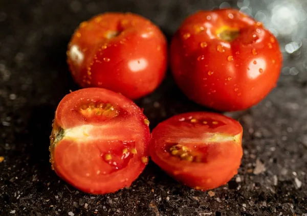 黒御影石のキッチンカウンターの表面に水滴と新鮮な熟したトマトの閉鎖 — ストック写真