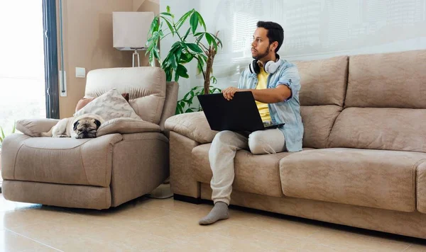 Egy Fiatal Férfi Fejhallgatóval Aki Laptoppal Dolgozik Otthonról — Stock Fotó