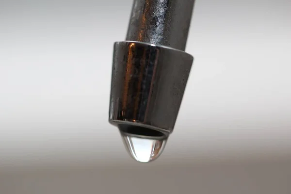 白い背景に金属製のシンク上の水の滴のクローズアップショット — ストック写真