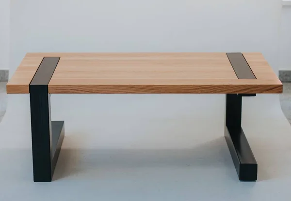 A futuristic table made of a wooden surface and black metal