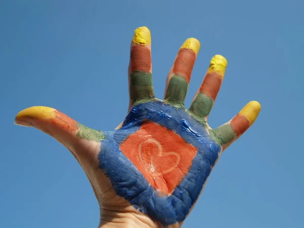 Низькокутний Знімок Різнокольорової Фарбованої Руки Синьому Фоні — стокове фото