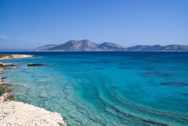 The beautiful Greek island of Koufonissi.  Crystal clear calm waters with a view to the island of Keros, which has an Minoan archealogical site. clipart