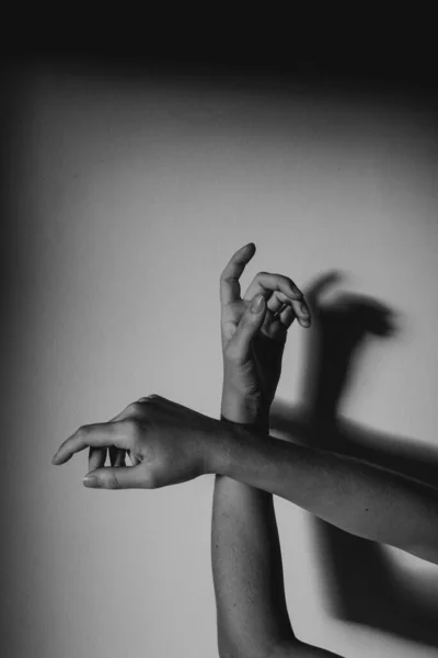 壁に影のある優雅な手の灰色の垂直ショット — ストック写真