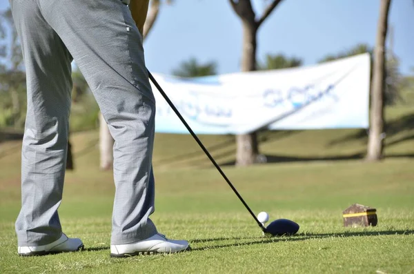 ゴルフクラブで白いボールを打つ青いズボンを持つ男性の選択的フォーカスショット — ストック写真