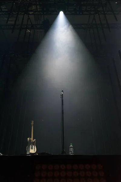 舞台上聚光灯下的吉他和话筒 — 图库照片