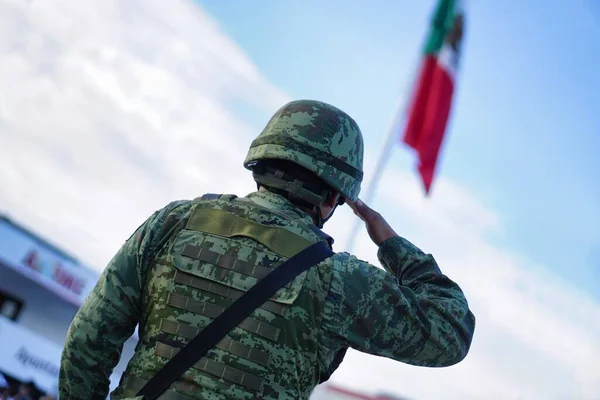 A Mexican soldier with a uniform and a mexican flag
