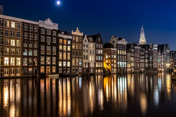 Amsterdam Damrak Światłami Refleksji Nad Wodą Wieczorem Holandii — Zdjęcie stockowe