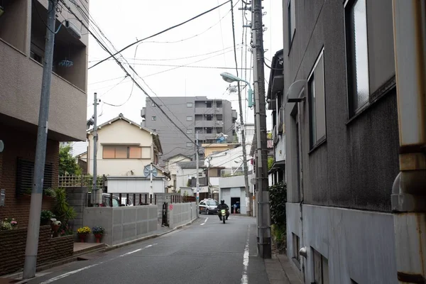 白い空の下の高層ビルに囲まれた狭い通り — ストック写真