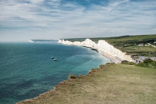 イギリス サセックスの昼間に曇った空の下で海に囲まれた7人の姉妹チョーク崖 — ストック写真