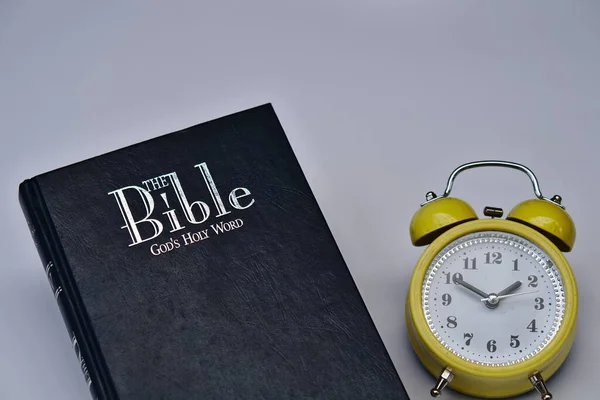 Svart Bibelbok Och Gul Väckarklocka — Stockfoto