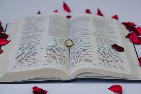 Ein Goldener Ring Auf Einem Buch Mit Roten Rosenblättern — Stockfoto