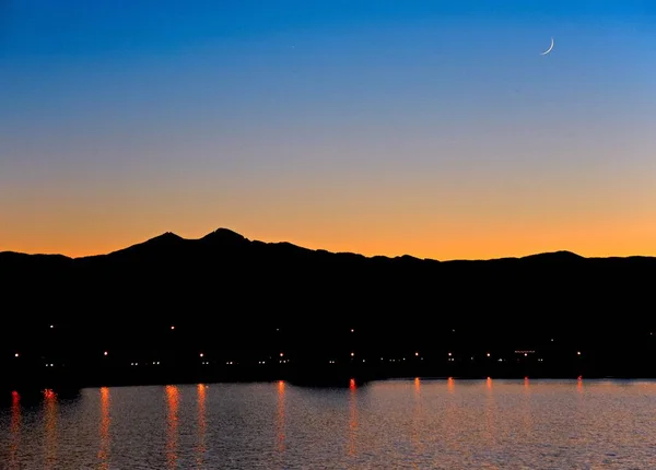 Una Silueta Una Gama Montañas Junto Lago Atardecer — Foto de Stock