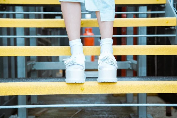 Uma Pessoa Usando Sapatos Brancos Passos Amarelos Com Fundo Embaçado — Fotografia de Stock