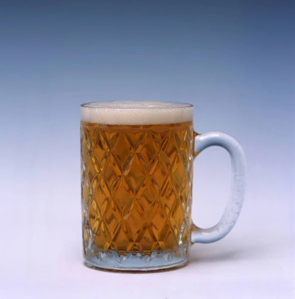 Widok Orzeźwiającego Piwa Pianką Szklance Białym Niebieskim Tłem — Zdjęcie stockowe