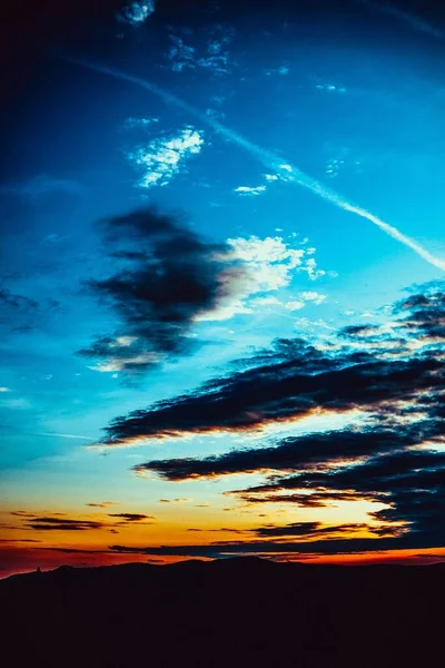 Gün Batımında Turuncu Mavi Bulutlu Bir Gökyüzünün Altındaki Tepelerin Dikey — Stok fotoğraf