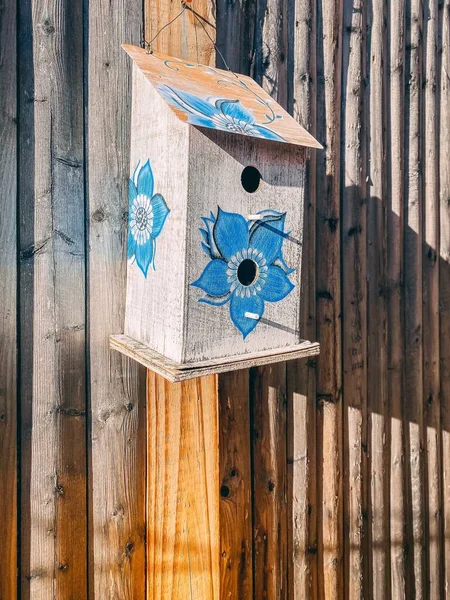 Eine Vertikale Nahaufnahme Blauer Blumen Auf Einem Hölzernen Vogelhaus — Stockfoto