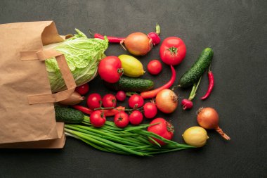 Siyah arkaplanda sebzeli bir süpermarketten bir kese kâğıdı.