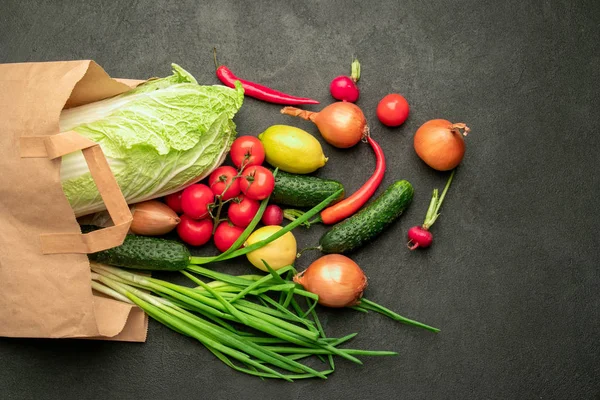 Em um fundo preto um saco de papel de um supermercado com verduras — Fotografia de Stock