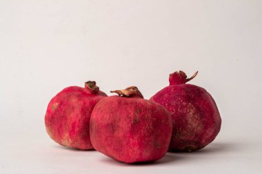 Açık arkaplanda kuru kabuklu üç kırmızı nar.