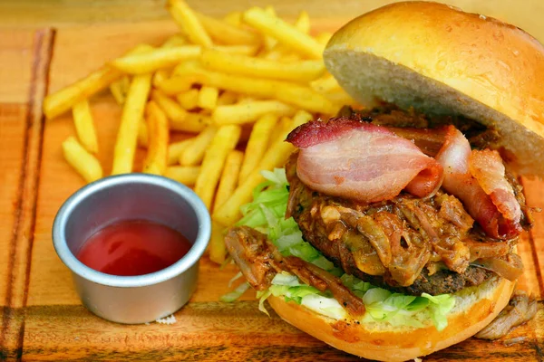 Hamburger with beef patty, bacon, lettuce and French fries meal