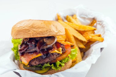 Hamburger, domuz pastırması, domates, marul, mantar, patates kızartmalı turşu ve siyah plastik kasede servis edilen patates kızartmasından oluşur.