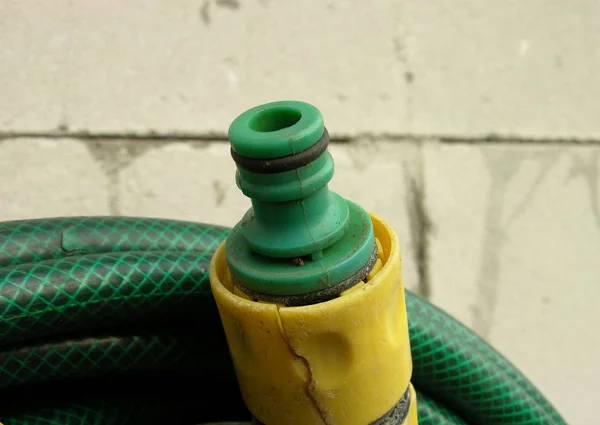 Plastic transitional connection-nozzle on the watering hose. Close-up shooting, narrow focus.