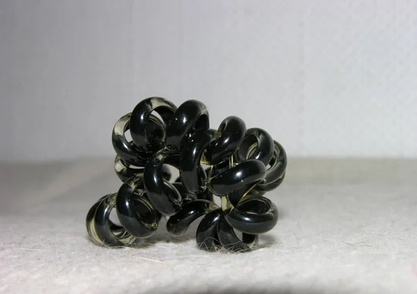 Kıvrılmış silikon elastik bant tüylü bir yüzeyde saç yayları şeklinde. Makro, odaklan.